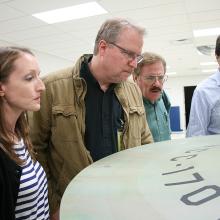  Denise Okuda, Ariel O’Connor, John Goodson, Rick Sternbach, and Adam Schneider study the original weathering streaks that had been subtly painted on the top of the saucer prior to filming