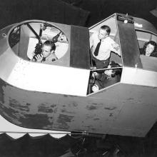 A woman with three male students in a simulator. 