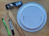 Materials used to create a safe eclipse solar viewer, including glasses, a plate, a rule, pen, and pencil. 