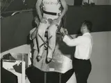 Man in full body restraint being lowered into a centrifuge. 