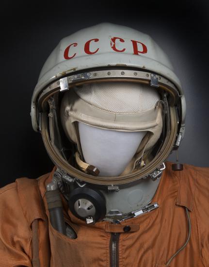 A helmet with CCCP on it, on a mannequin in a white suit.