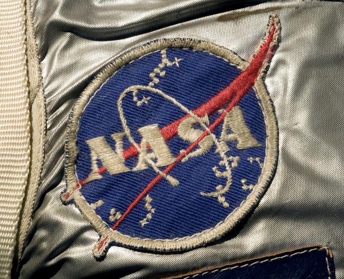 A detail of Alan Shepard's spacesuit featuring the "meatball" patch, a blue circle with the text "NASA" on it and a red swoop. 