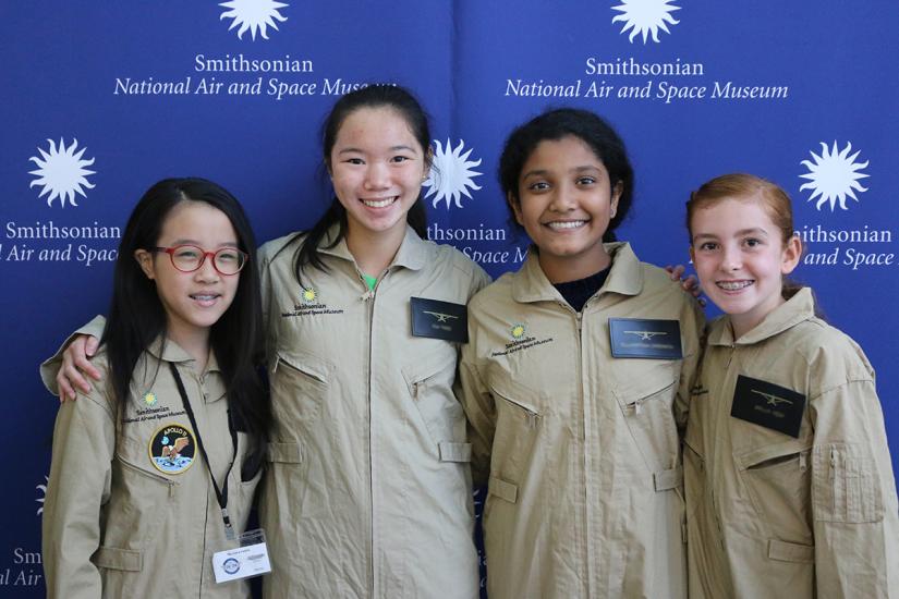 Four young women wearing flight suits. 
