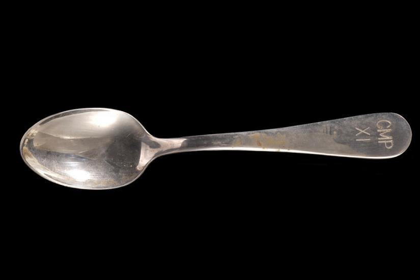 A metal spoon with "Cup XI" inscribed on the handle. 