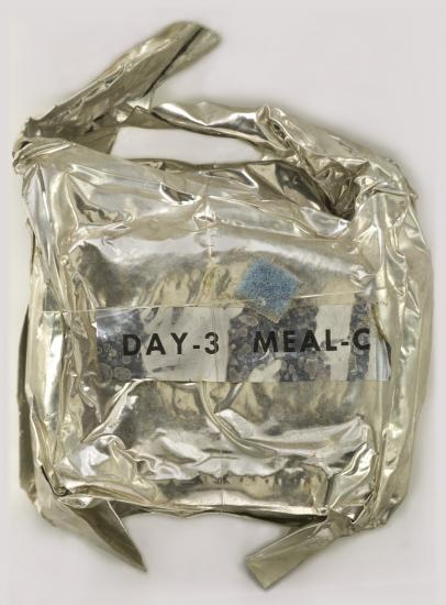 A metal package with a blue sticker and "Day 3 Meal C" on the outside.