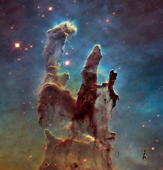 What appears to be three vertical pillar clouds stretching up above a starry field.