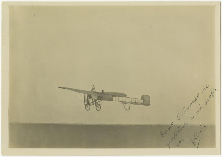black and white photo. One-half left rear view of monoplane several feet off the ground.  Handwritten text in lower right corner.