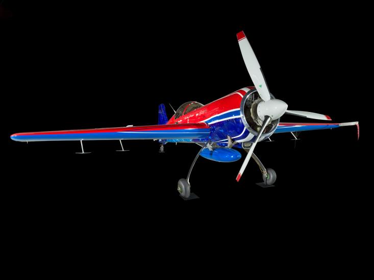 Red and blue painted plane. From this angle, you can see the propellers, landing gear, and fuselage of the plane. 