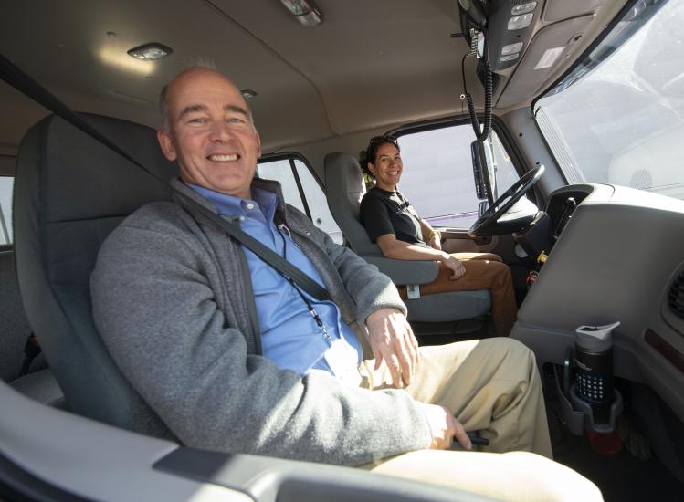 Two people in a truck smiling and posing for a picture.