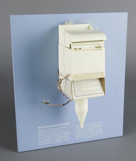 A white device that looks like a mailbox or soap dispenser with a pointed cone emerging from the bottom.