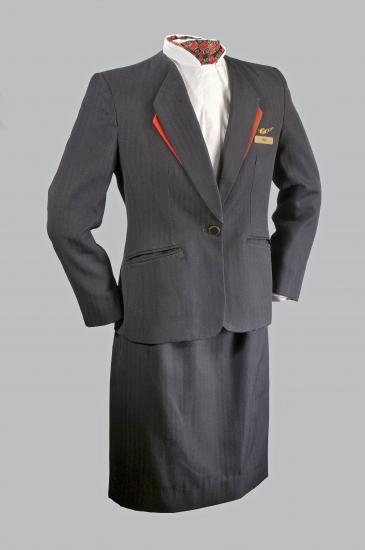 A photo of a dark colored formal uniform on a mannequin. The name tag says Tami.