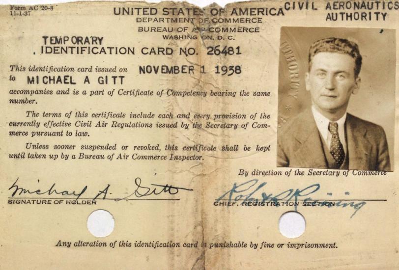 Card, ripped at the top with two holes punched in the bottom.  Text at top: United States Department of Commerce, Civil Aeronautics Authority. Small vertical photo in the upper right hand corner: White man with medium colored tousled hair wearing a suit and tie. Two signatures at the bottom: (left) Michael A. Gitt (Right) Robert K. Reining