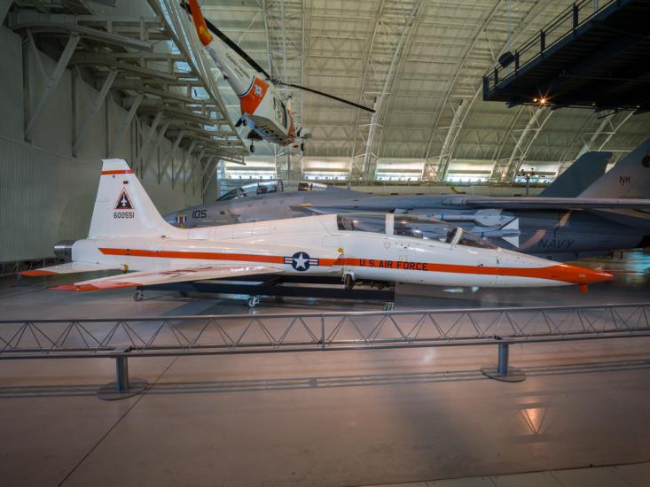 View of a white and orange painted airplane in the museum hanger.