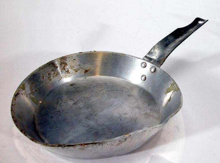 A thin frying pan which shows signs of use.