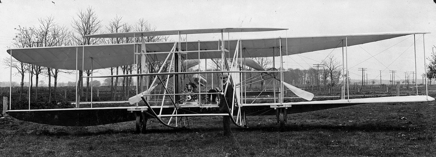 Front of a wright airplane on the ground.