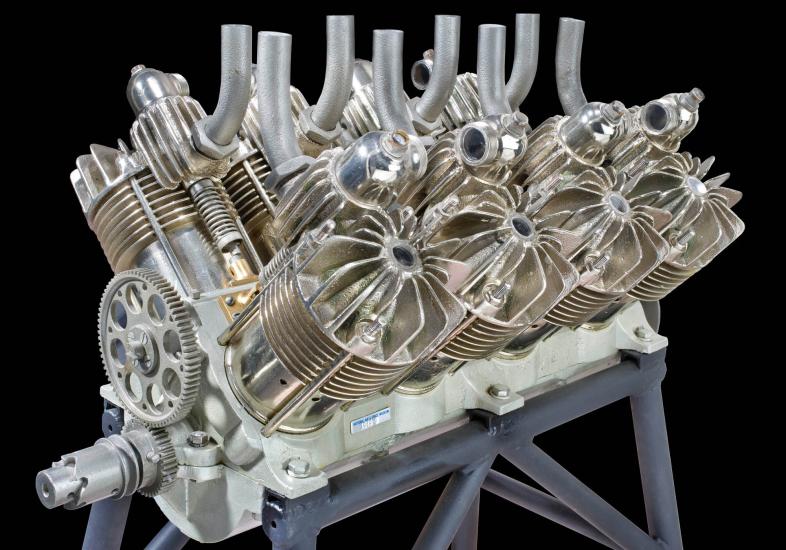 Reciprocating, V-type, 8 cylinder, air-cooled silver colored engine on a black background.