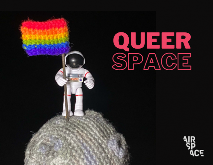 Astronaut standing on crocheted Moon holding Pride flag, with text next to it that says QueerSpace