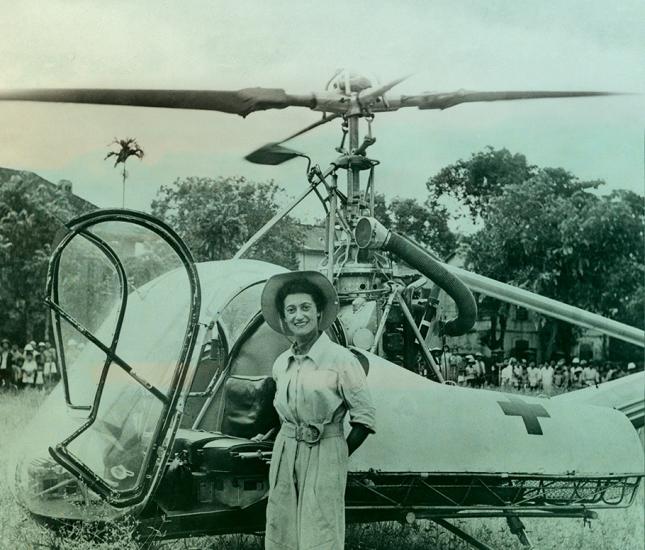 Doctor Valerie Andre in front of her helicopter with jungle in background