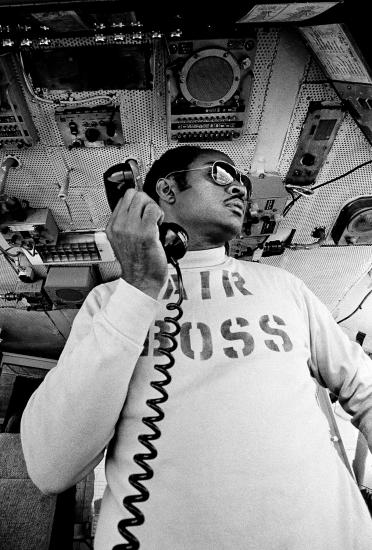 Man holding a phone on the flight deck of a ship