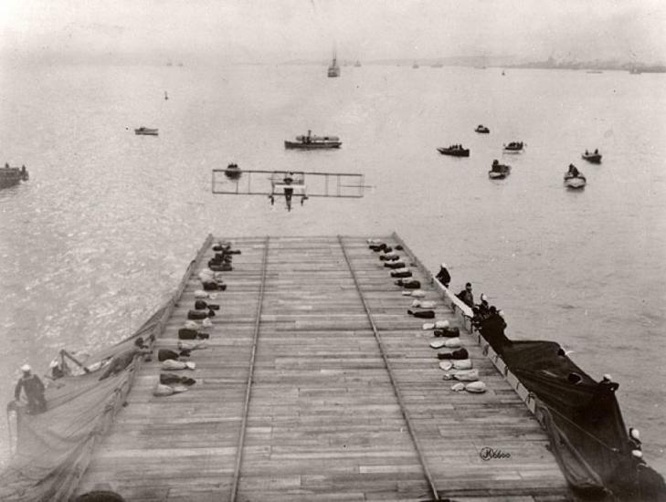 A ramp over water with a biplane approaching it.