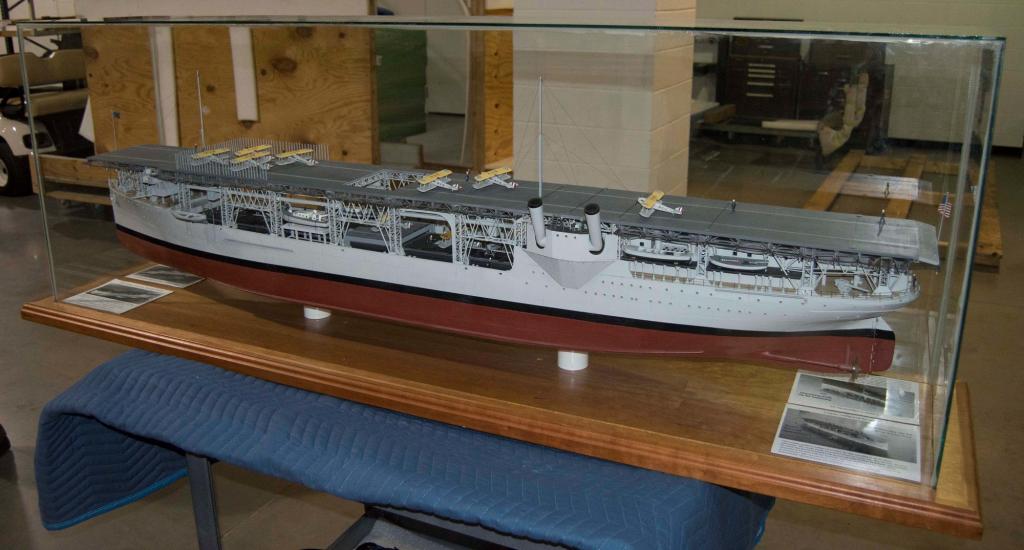 A model of an aircraft carrier inside clear case.