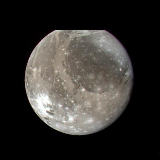 A circular moon in various shades of grey with several bright white circles on it. 