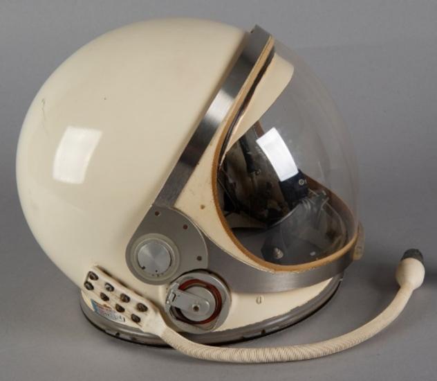 A helmet is photographed from the side against a grey background.