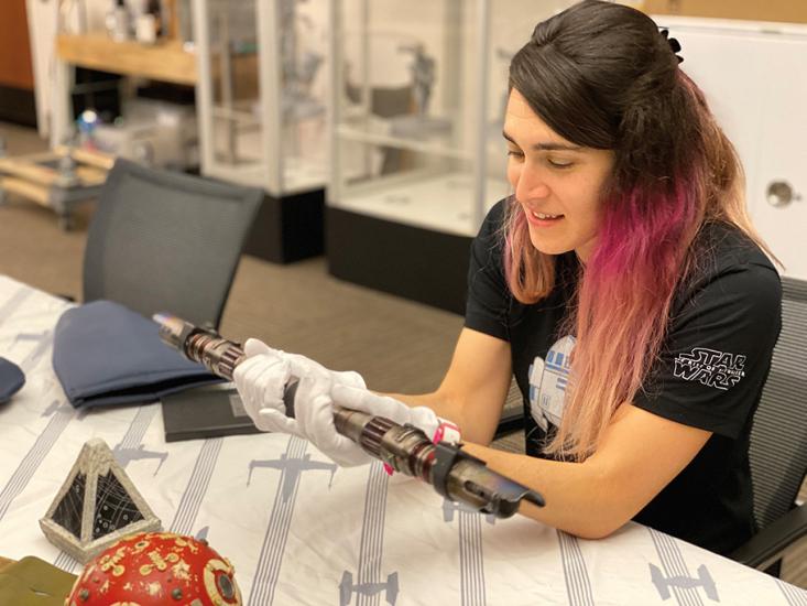 Candid  Walt Disney Company archivist Madlyn Moskowitz holding Star Wars Dark Side Rey’s lightsaber.