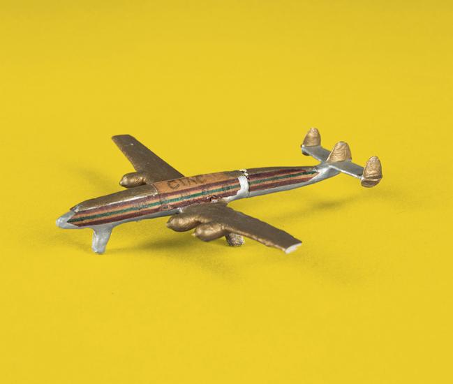 A tiny model of a Lockheed L-1049 Super Constellation that was made from household items like matchsticks, cardboard, and chewing gum.