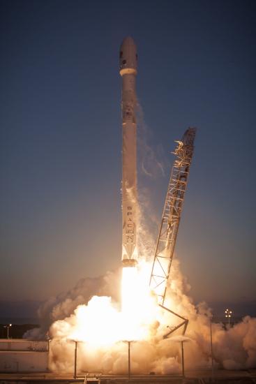 A rocket launching. You can see a stand that was holding it lean away to the left, and the fire of the launch below. 