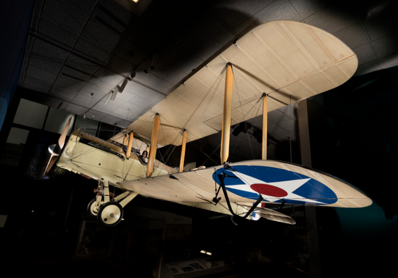 A picture of a beige biplane with a star in a circle on the wing. 