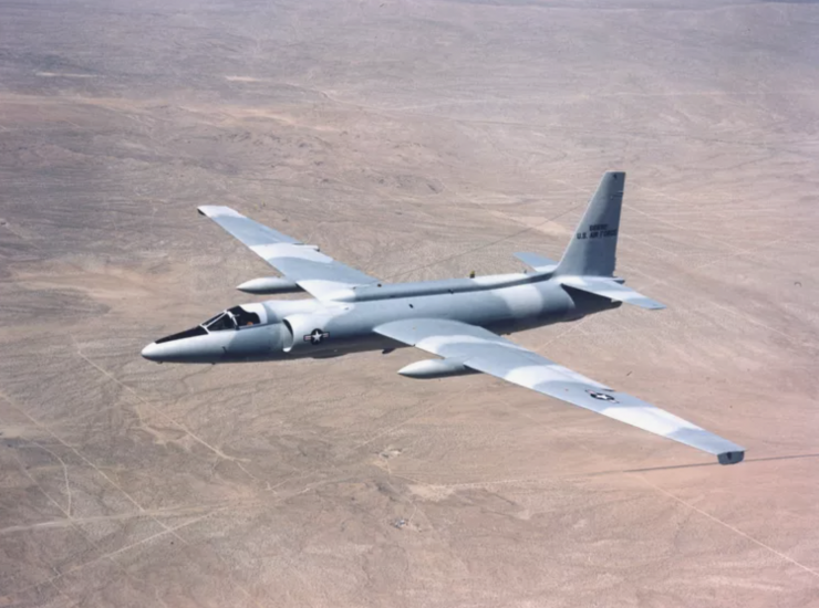 A grey-blue camouflaged plane in flight. 