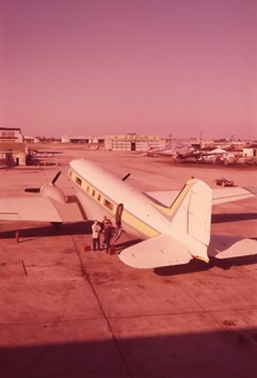 A photo taken from behind the tail of the plane, providing a three-fourths view of the plane from behind. The plane looks similar to a commercial airliner.