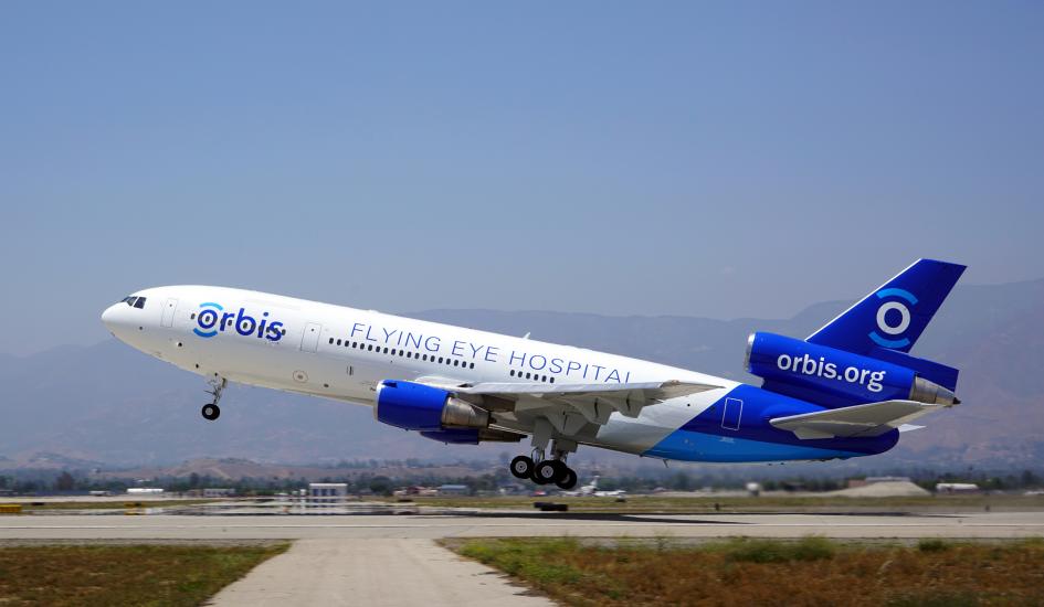 A plane taking off that reads "Orbis, Flying Eye Hospital, orbis.org" on the side. 