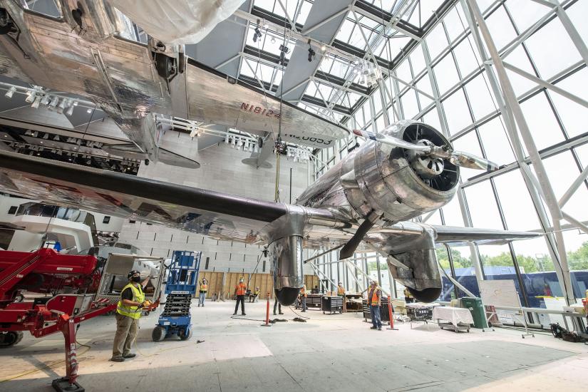 Silver aircraft being suspended in a gallery