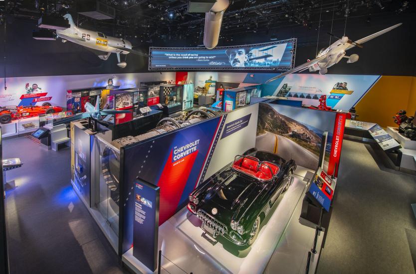 An overhead view of the Nation of Speed gallery. A Corvette and two suspended aircraft are visible. 