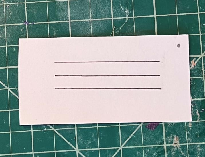 A piece of paper cut into a rectangle with three horizontal parallel lines on it. 