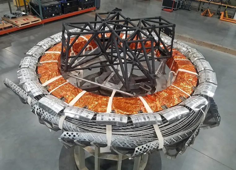 The antenna of a satellite in photographed in an interior setting.