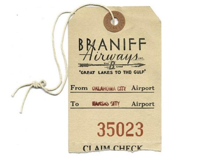 A manila luggage tag with Braniiff Airways "Great Lakes to the Gulf" printed on top. The tag reads "From Oklahoma City Airport to Kansas City Airport 35023 Claim Check"