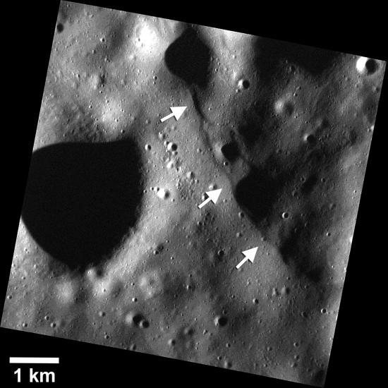 Three arrows point to a ridge in the surface of Mercury.