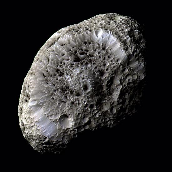 An oval shaped asteroid covered in crater marks.