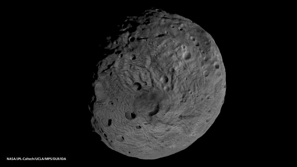 A globe shaped asteroid with a cratered surface. 