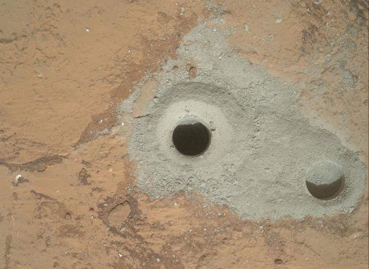 The surface of Mars with a hole bored into it. 