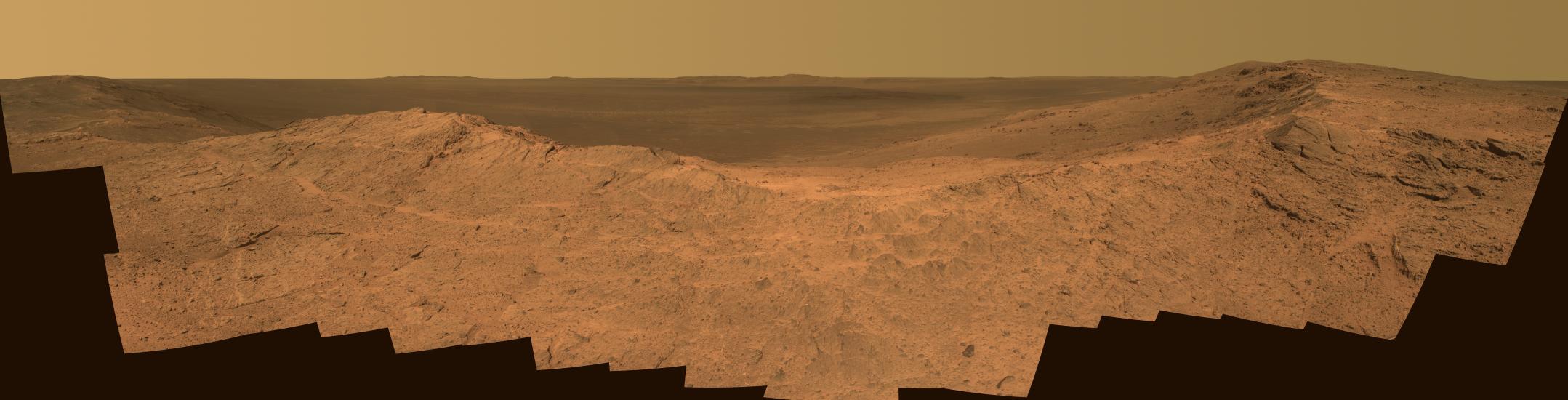 A panoramic view of the dusty red terrain on Mars.