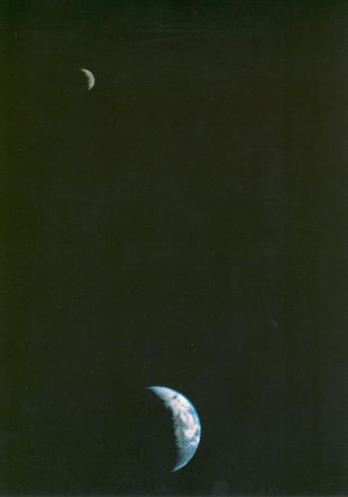 A photo of the Earth and Moon in the same frame. The Moon is in the upper left and the Earth is at the bottom of the frame in the middle.