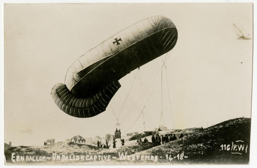 A balloon being pulled down by a group of people.