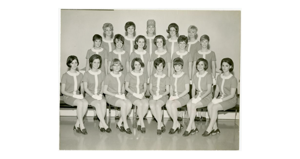 A group of flight attendants pose for a picture.