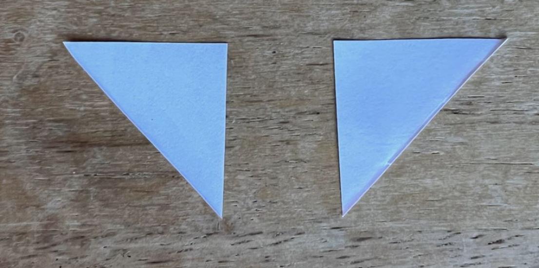 Two small right triangles made of paper.