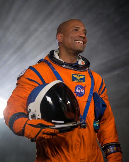 Victor Glover wearing an orange flight suit. 