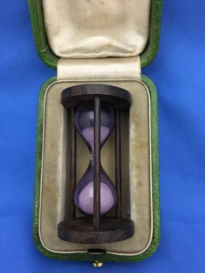 Small hourglass in a box lined with purple fabric